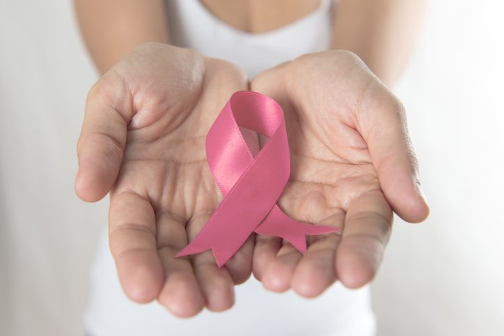 Woman holding Breast Cancer Awareness Ribbon in hands