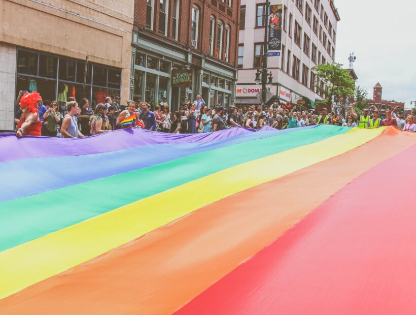 Portland Oregon Pride event with crowds celebrating, rainbow flags, and LGBTQ+ community gathering in downtown area.